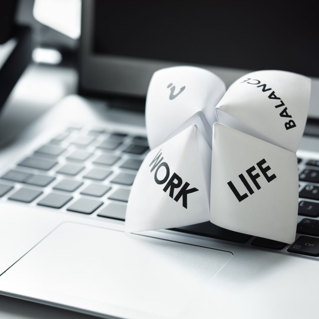 Origami fortune teller on laptop in office concept for work life balance choices